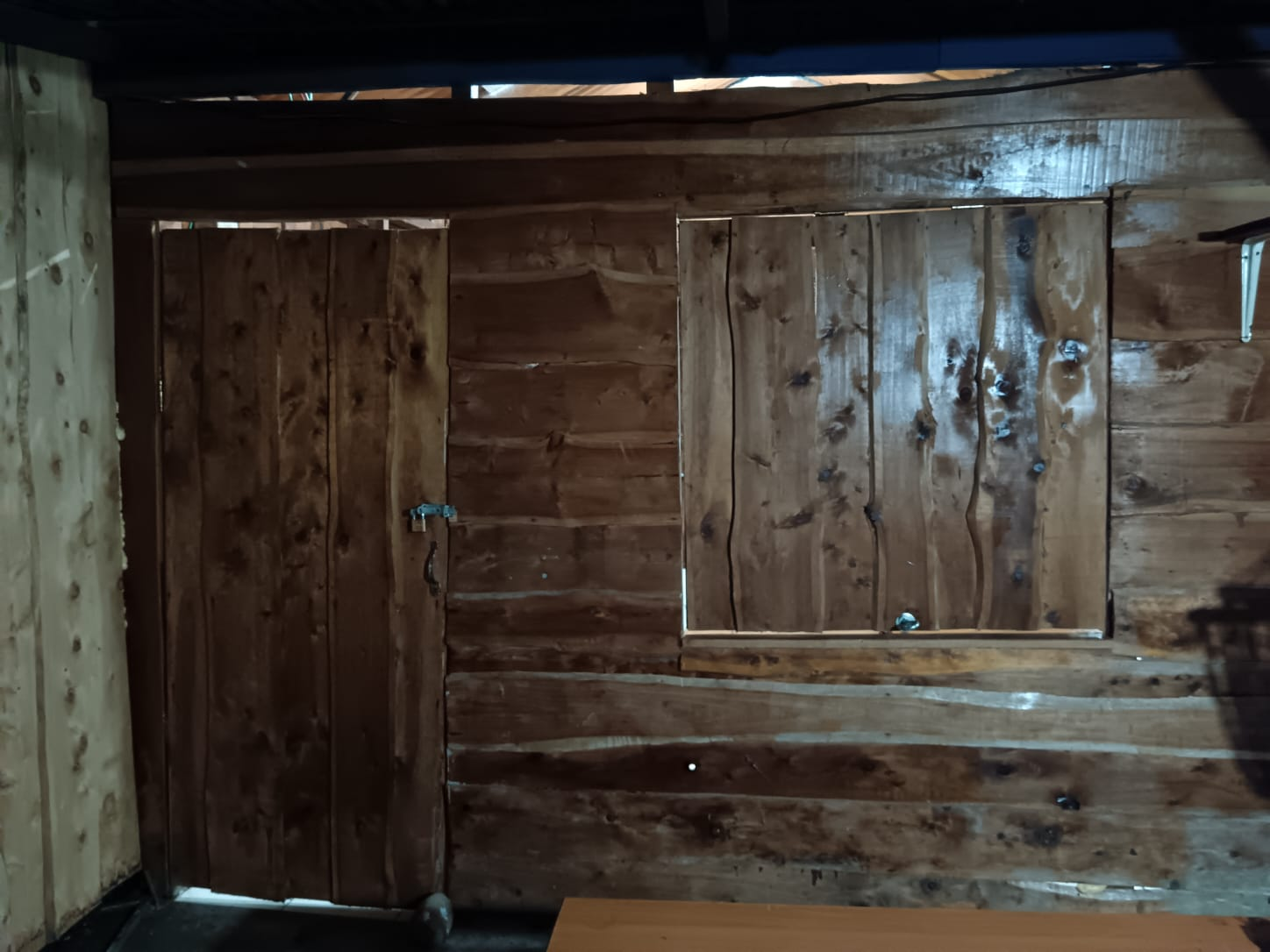 Interior rústico de madera con puerta y ventana