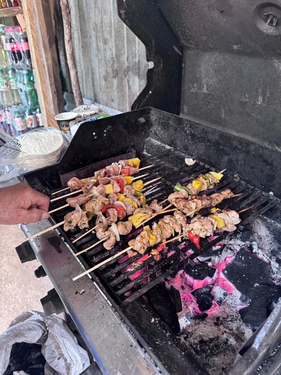 Brochetas de carne y vegetales asándose en la parrilla