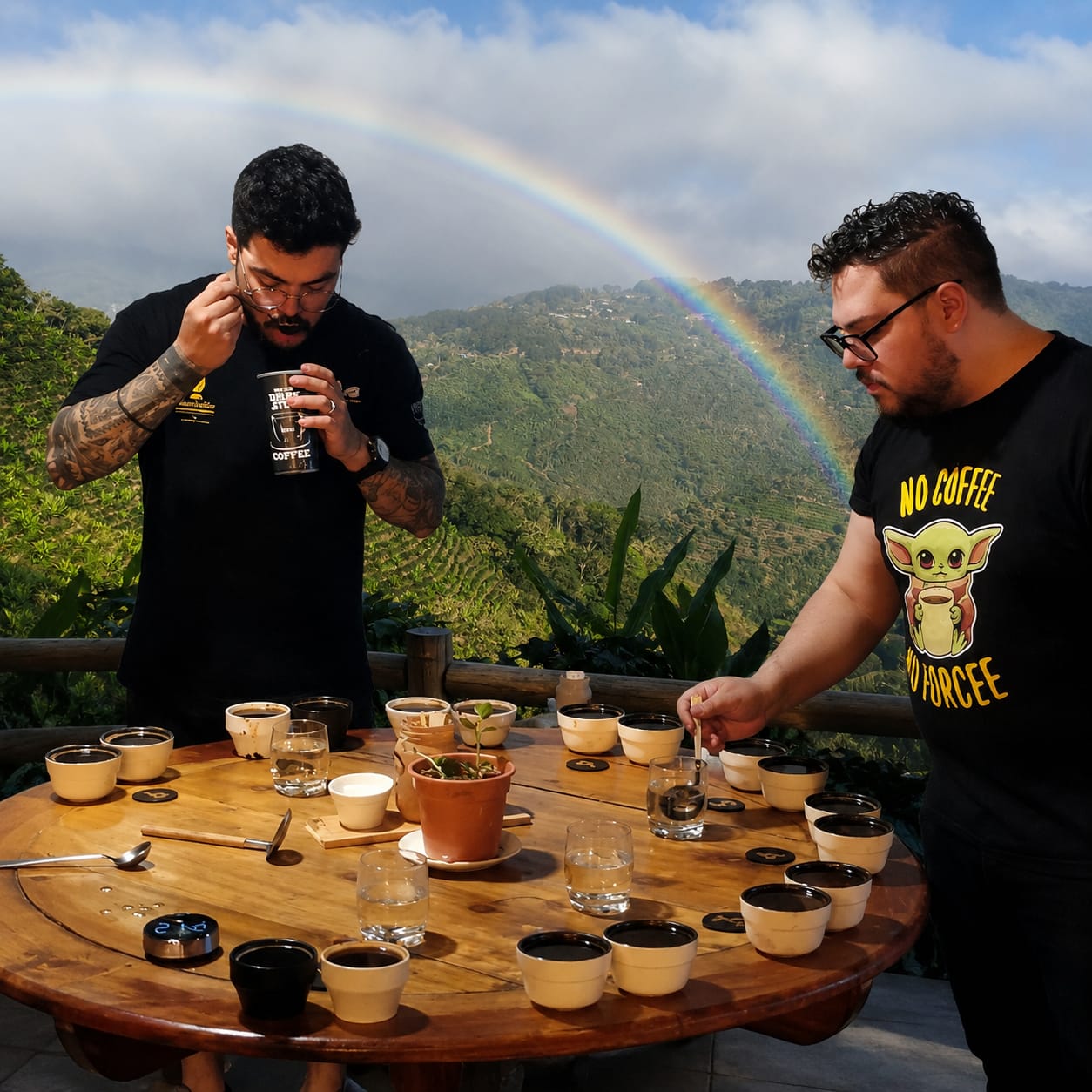 Dos personas disfrutando de una cata de café con vista a montañas y arcoíris