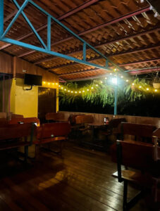 Interior nocturno con luces cálidas y mesas de madera
