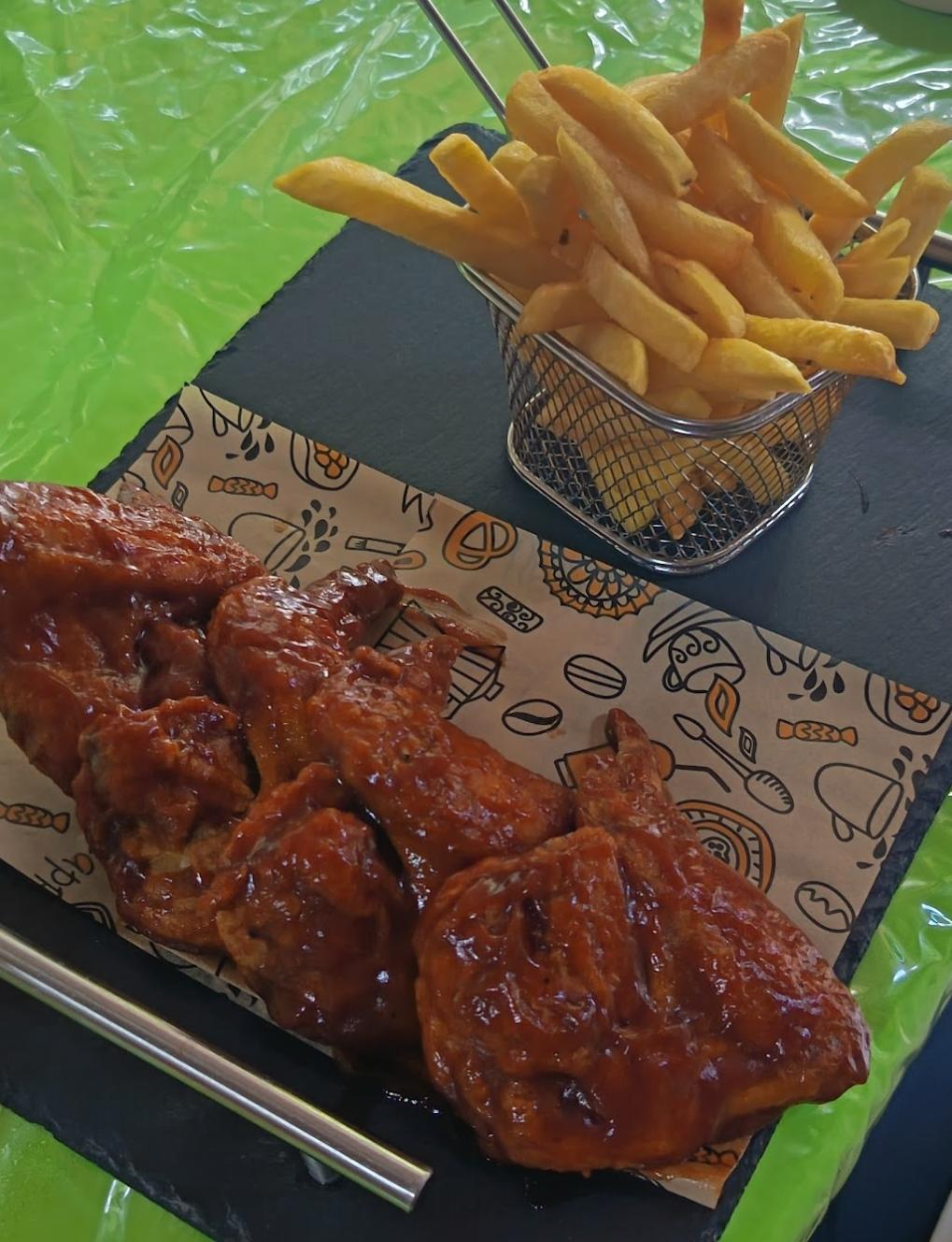 Alitas bañadas en salsa con papas fritas en Antojitos de Mi Alma