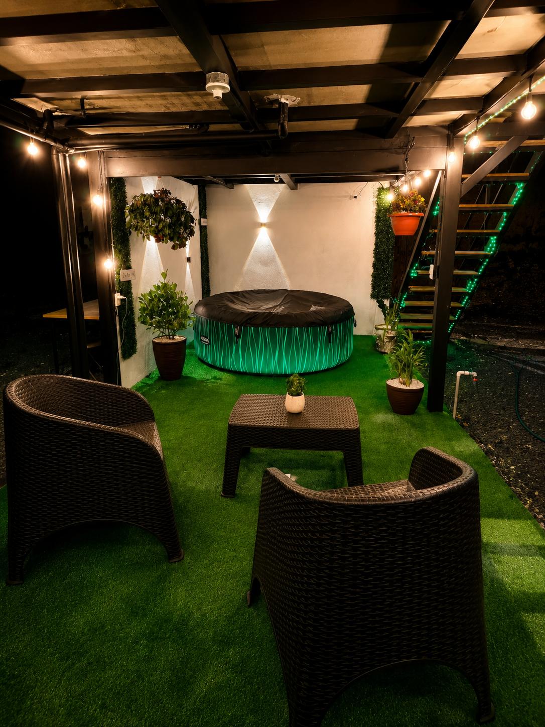 Área de estar con sillones frente al jacuzzi iluminado