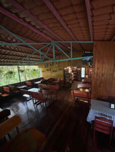 Salón interior con techo de madera y mesas listas para visitantes