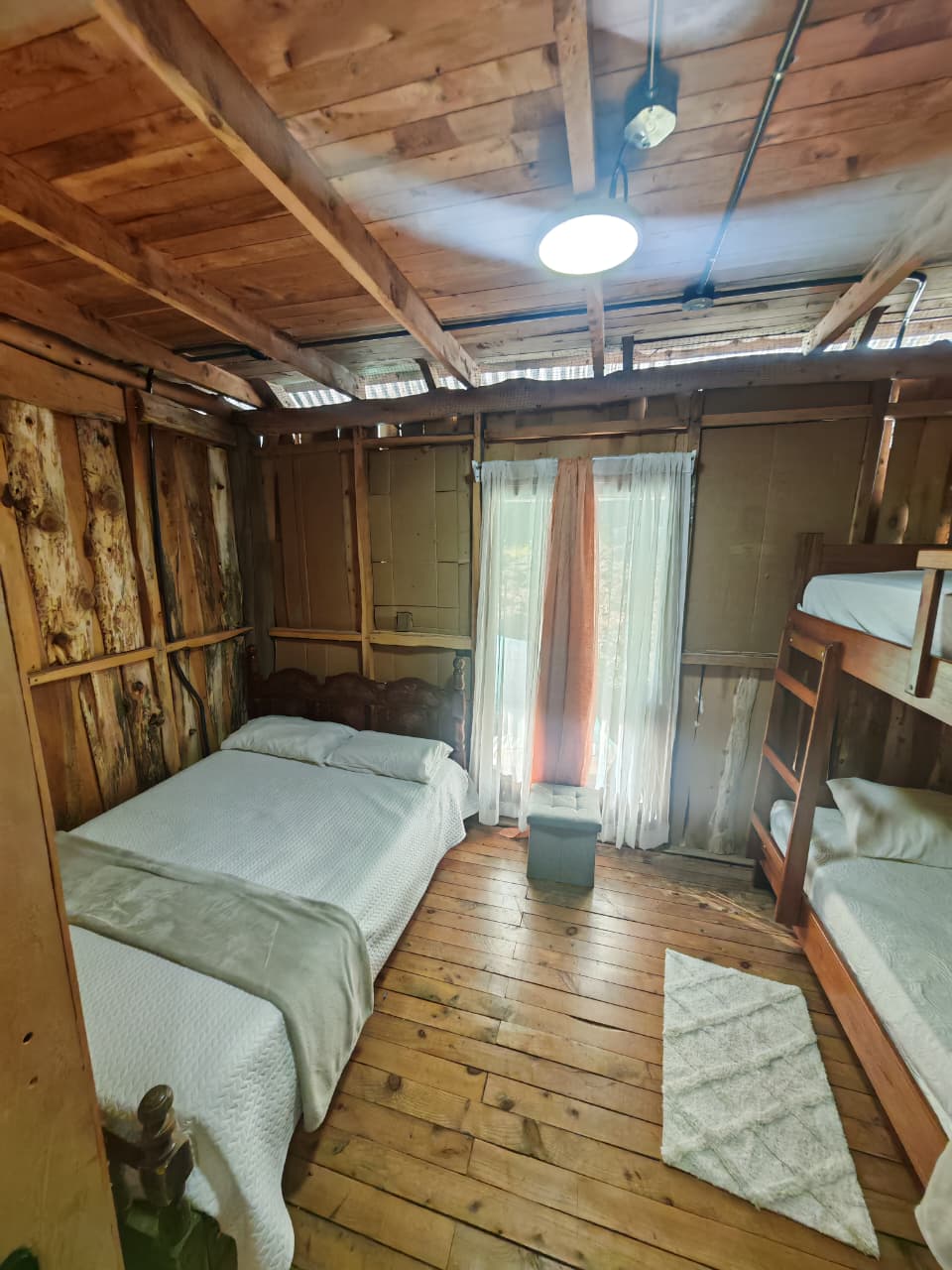Habitación rústica con cama y camarote