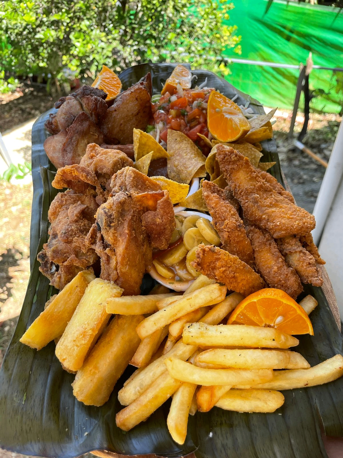 Plato de pollo frito con papas, yuca y acompañamientos en La Ranchilla