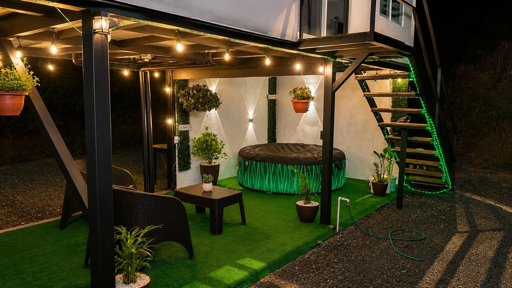 Terraza iluminada con jacuzzi y jardín en la noche