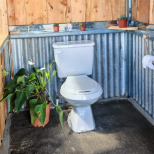 Baño rústico con paredes de madera y zinc
