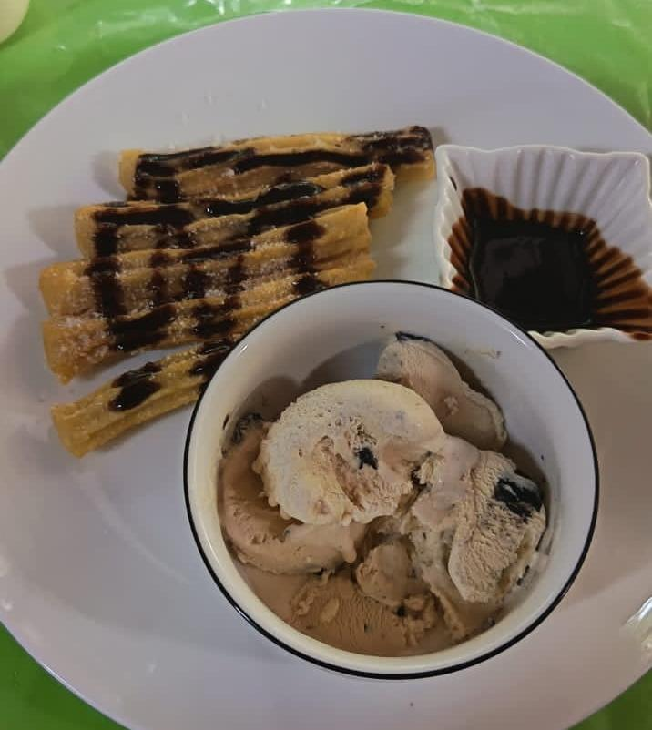 Churros con helado y chocolate servidos en plato en Antojitos de Mi Alma