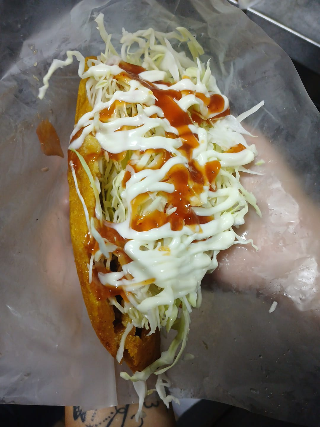 Taco crujiente con repollo, salsas y relleno servido en Antojitos de Mi Alma