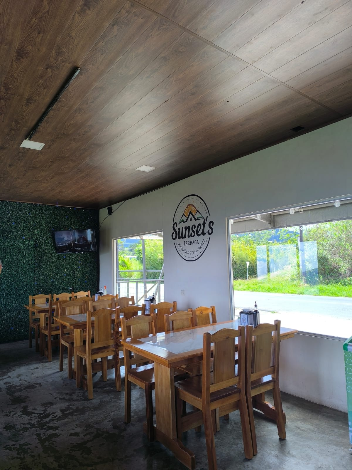 Salón interior con mesas de madera y ventanales