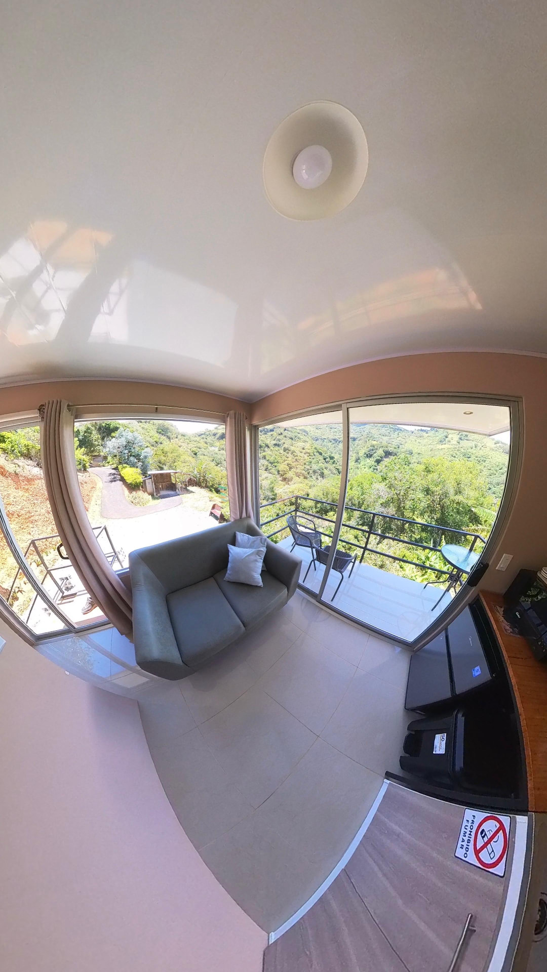 Sala con sofá y ventanales hacia la montaña