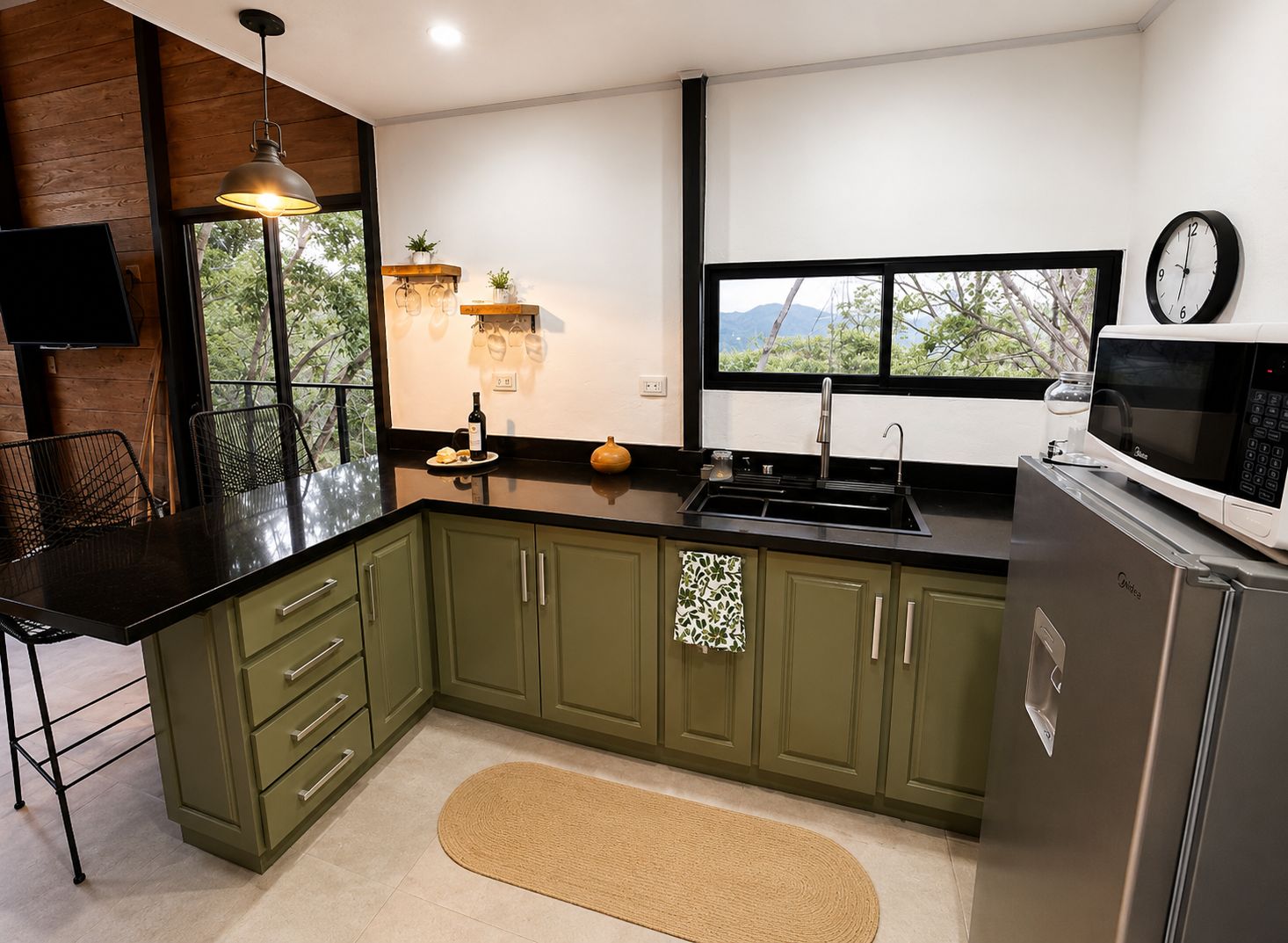 Cocina con gabinetes verdes y vista a las montañas