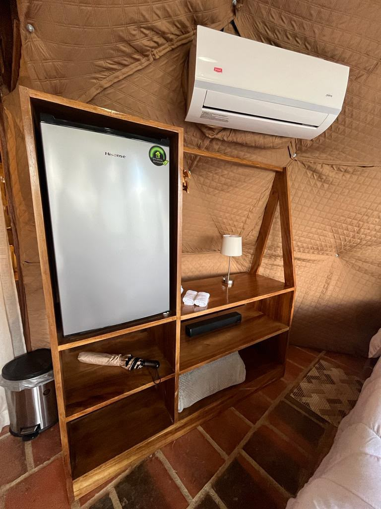 Mueble de madera con minibar y amenidades en el domo