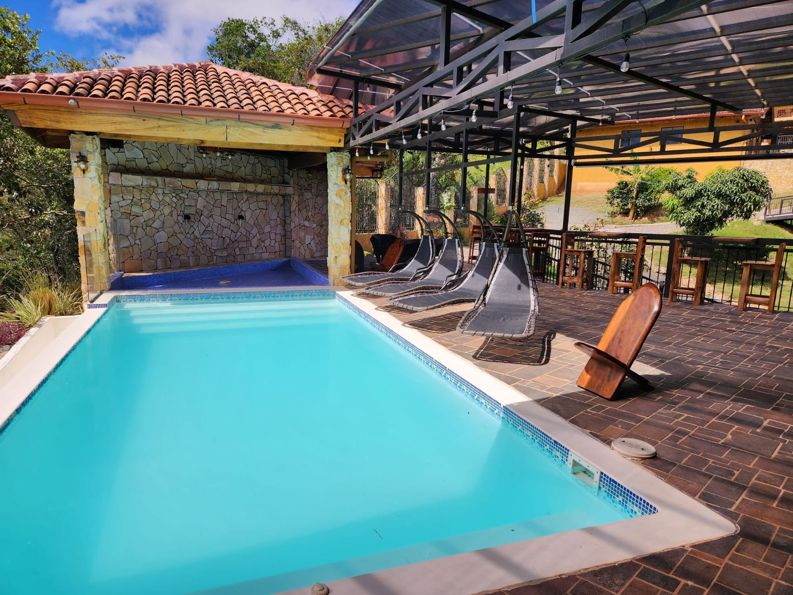 Piscina y área de descanso con camastros