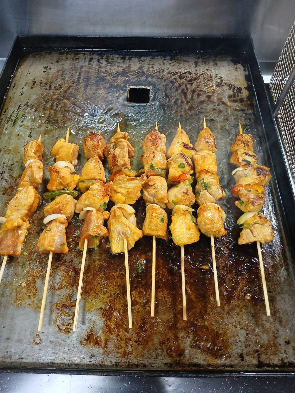Pinchos de pollo cocinándose a la plancha en Antojitos de Mi Alma