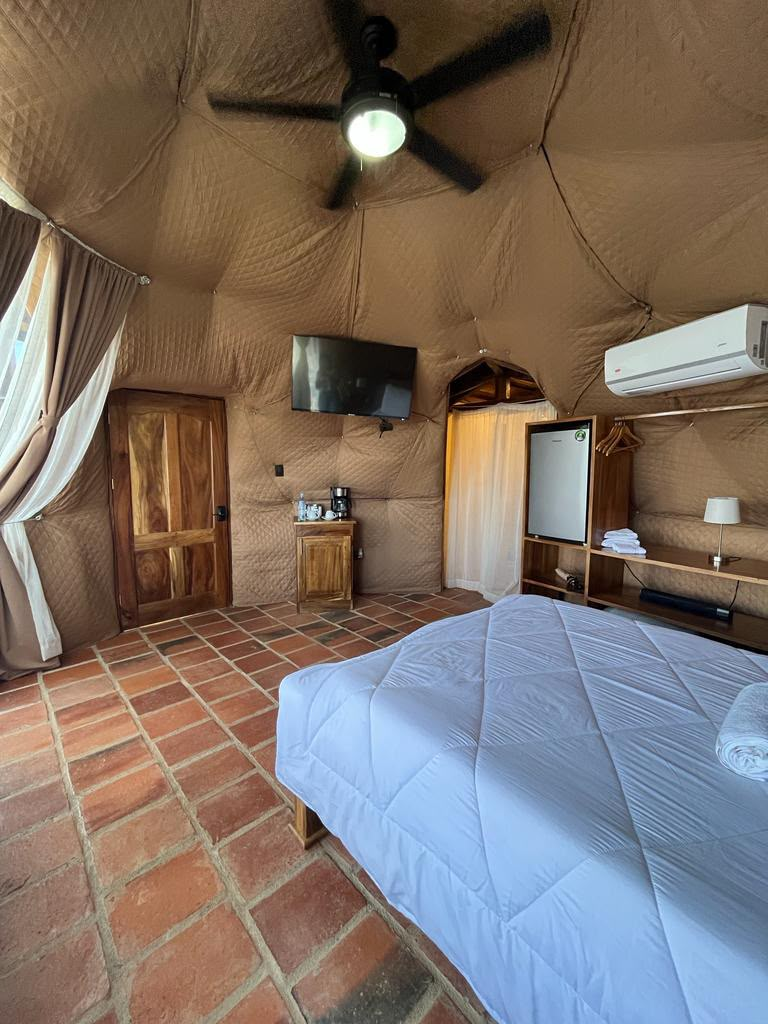 Interior del domo con TV, minibar y ventilador de techo