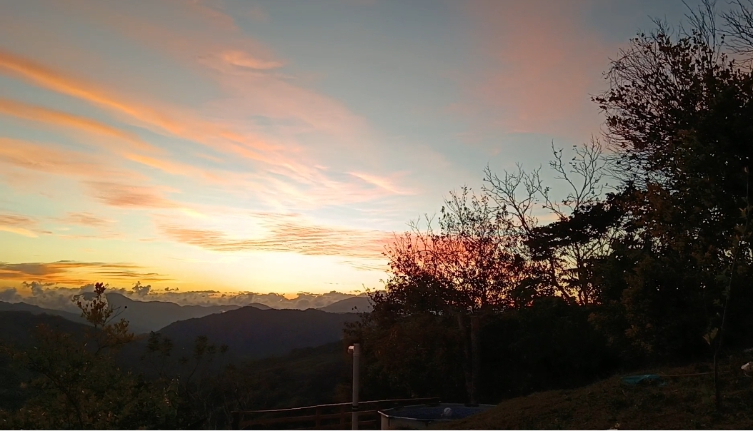 Cielo con nubes rosadas al atardecer sobre las montañas